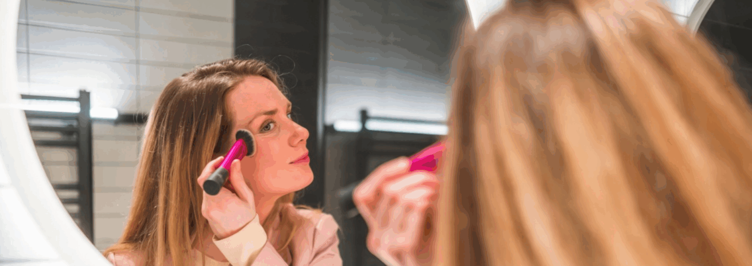 girl making up in front of a led mirror